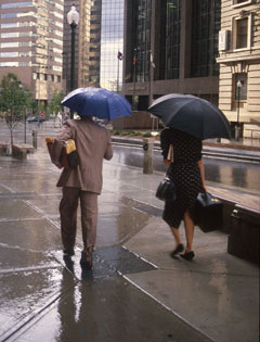 Rain falling on people with umbrellas